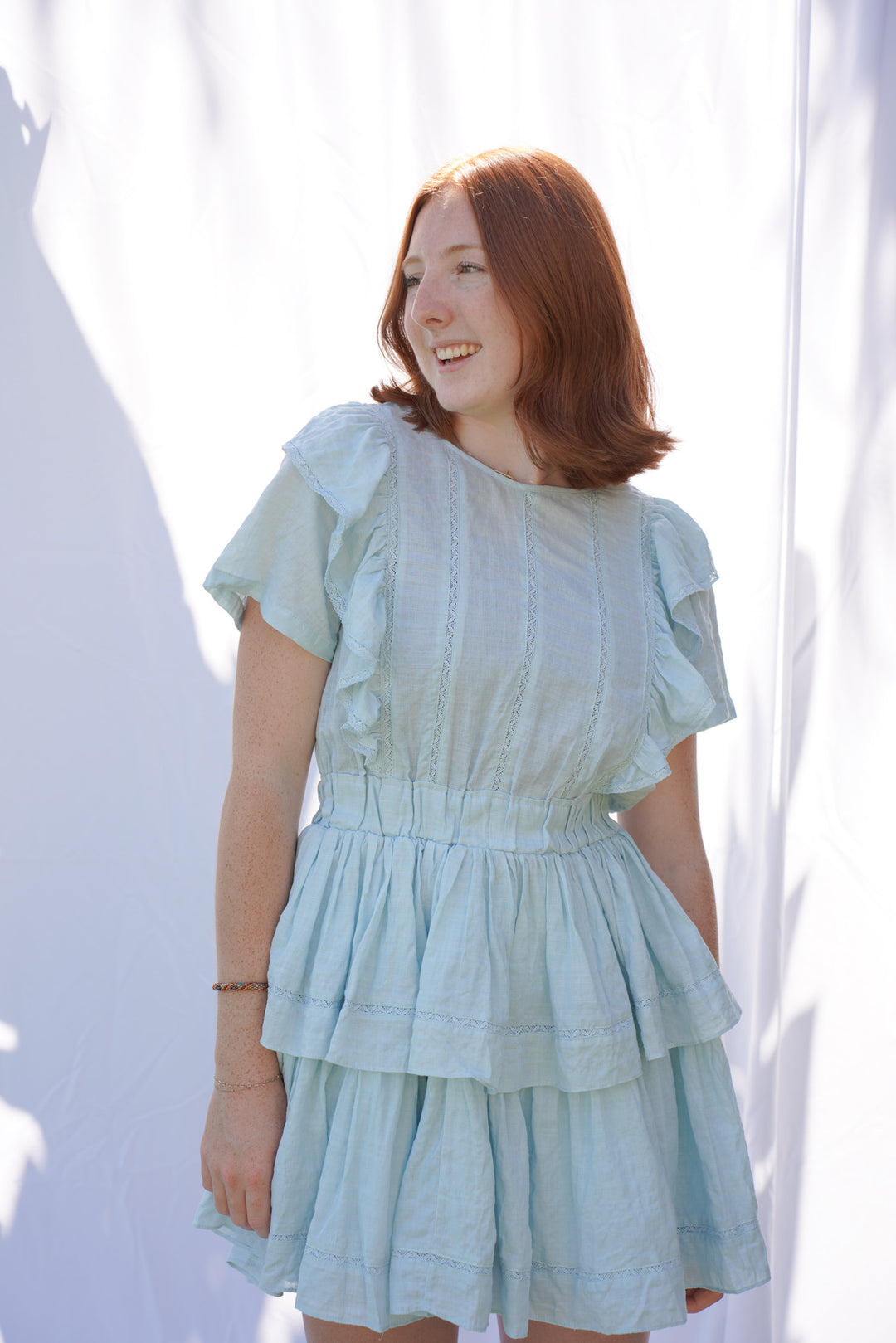 Women wearing blue ruffle dress with elastic waist and ruffle sleeves