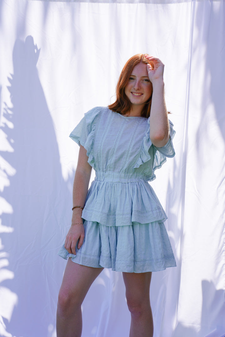 Women wearing blue ruffle dress with elastic waist and ruffle sleeves