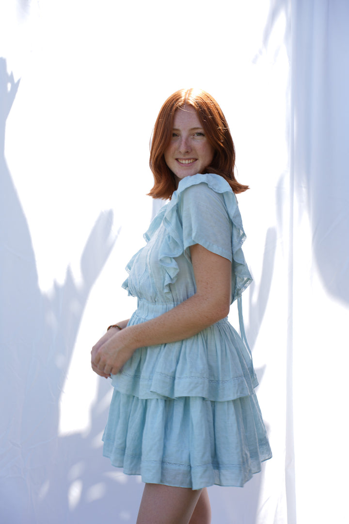 Women wearing blue ruffle dress with elastic waist and ruffle sleeves