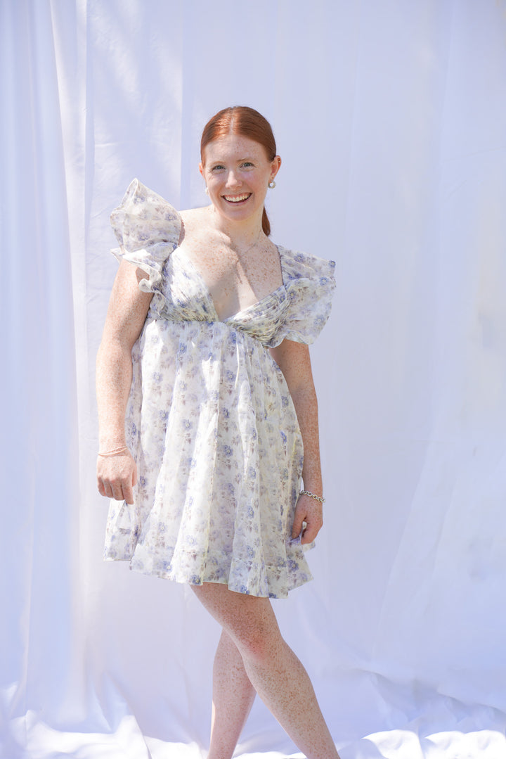 Women wearing floral blue organza dress with bow tie in the back