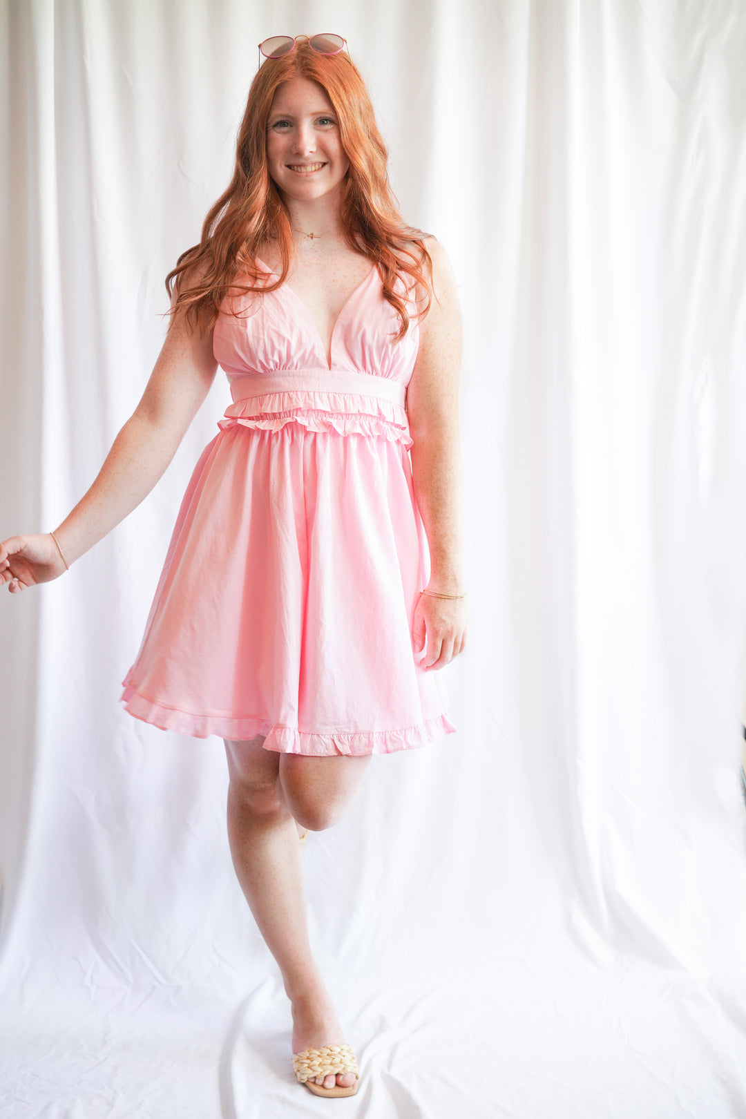 Pink sundress with deep v-neck opening and ruffle hem detail is made with 100% cotton