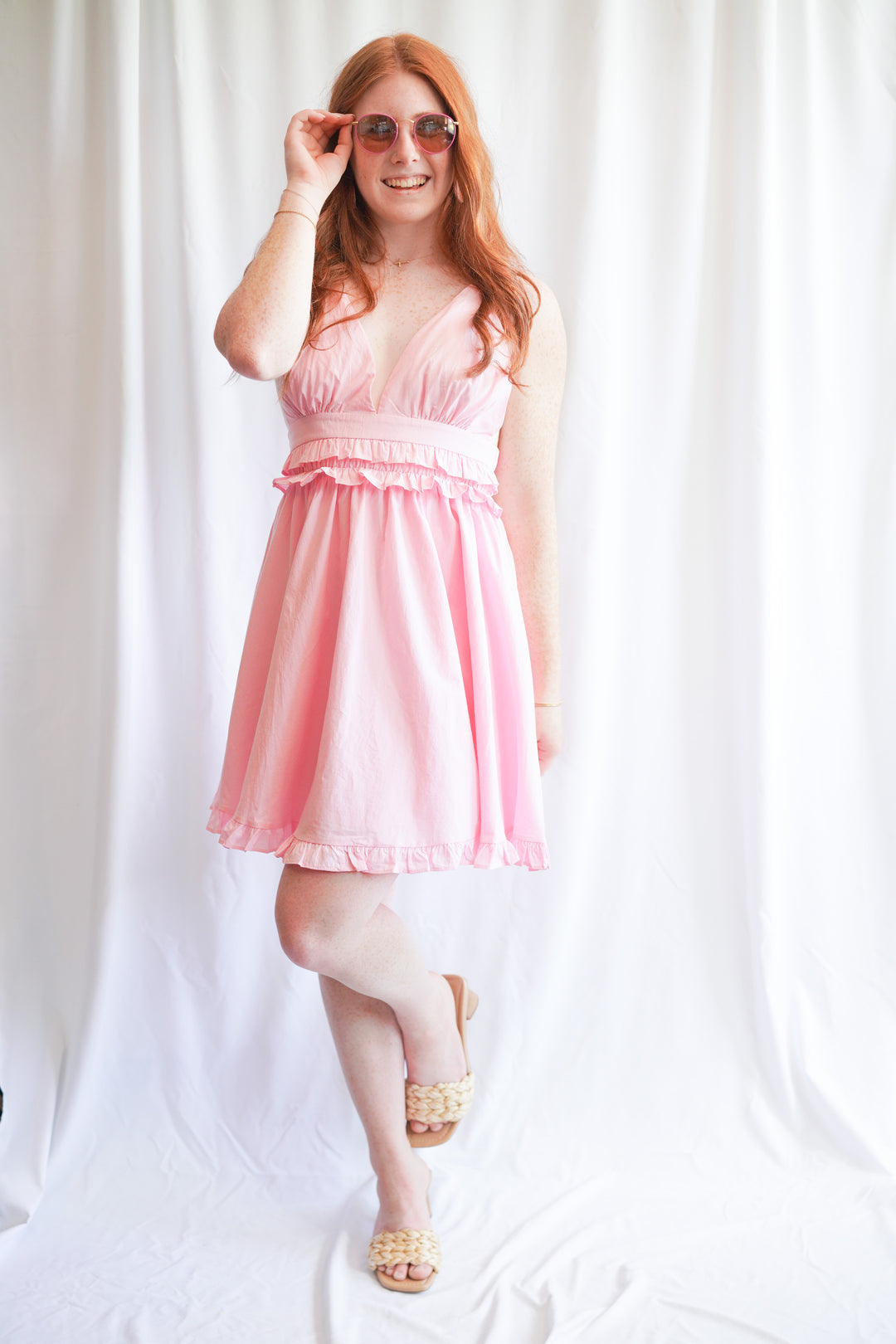 Pink sundress with deep v-neck opening and ruffle hem detail is made with 100% cotton